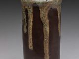 un vase marron et noir sur lequel on voit une coulure de peinture