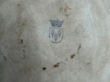 a close up of a white vase with a crown on it