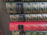 many books stacked on top of each other on a shelf