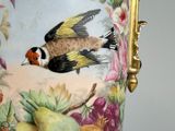 a vase with a bird painted on it with fruit and flowers