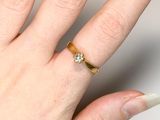 a woman ' s hand with a gold ring on it