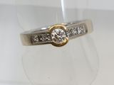 a close up of a diamond ring on a clear ring holder