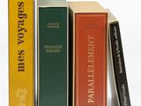 plusieurs livres sont empilés sur une surface blanche