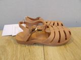 sandals with straps and buckles are on a wooden table
