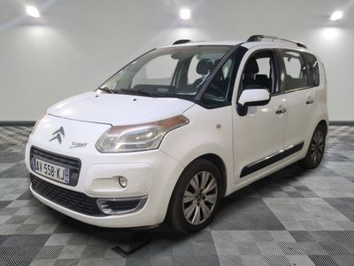la petite voiture blanche est garée sur un carrelage à carreaux
