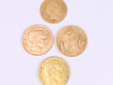 four different types of gold coins on a white surface