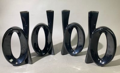 trois vases noirs posés les uns à côté des autres sur une table