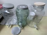 three glass jars with lids on a table