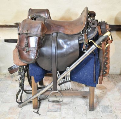 a horse saddle with a sword and other items on it