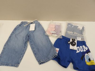 deux paires de jeans et un pantalon posés sur une table