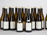 six bouteilles de vin sont alignées sur une table