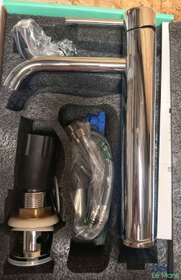 a box with a pipe, a hose, and other items in it