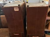 Dans un magasin, deux fauteuils en cuir marron sont empilés l'un sur l'autre.
