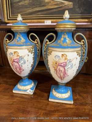 une paire de vases bleus et blancs posés sur une table, avec un tableau en arrière-plan