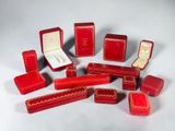 de nombreuses boîtes rouges ornées de motifs dorés sur un fond blanc