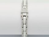 a close up of a diamond bracelet on a white surface