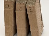 three old books stacked on top of each other on a white surface