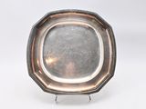 an antique silver plate on stand on white background