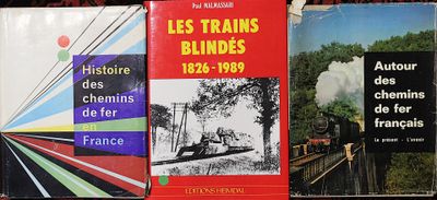 trois livres sur une étagère, avec un train en arrière-plan