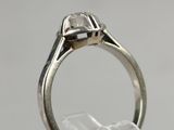 a close up of a ring with a diamond in it on a clear surface