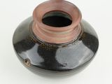 a black and brown vase with a brown lid