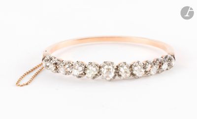 une bague en or rose ornée de cinq diamants, suspendue à une chaîne