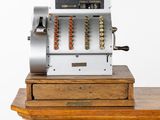 une caisse enregistreuse à l'ancienne posée sur une table en bois