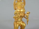 an image of a gold statue of a person holding a bird