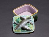 a small box with a fish on it sitting on a table