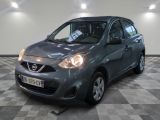 La petite voiture grise est garée dans le garage, sur un sol à damier.