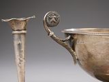 an image of a silver cup and a silver spoon on a table