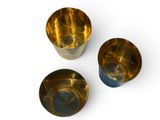 three metal cups sitting on a white surface