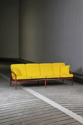 a yellow couch sitting in the middle of a room