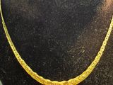 an image of a gold necklace on a mannequin display