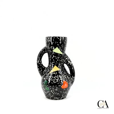 un vase noir et blanc orné d'un oiseau
