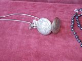 a necklace with a coin on it and a necklace with a bead