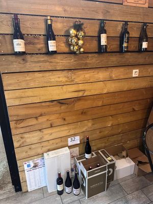 Des bouteilles de vin sont alignées le long d'un mur dans un magasin de vins.