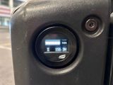 a close up of a clock on the side of a black suitcase