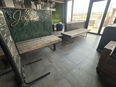 deux bancs en bois dans une pièce dotée de grandes fenêtres