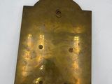 an old brass plate with holes in the middle of it