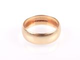 a close up of a gold ring on a white surface