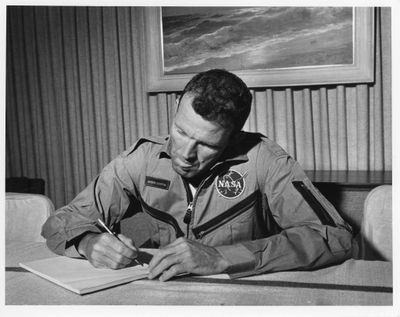 photographie en noir et blanc d'un homme en uniforme en train d'écrire sur une feuille de papier