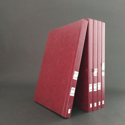 three red binders stacked on top of each other on a gray surface