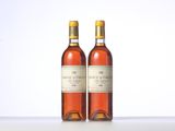 two bottles of wine sitting on top of a table next to each other
