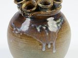a brown vase with a bunch of coins in it