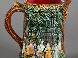 a ceramic pitcher with a painting on it on a table