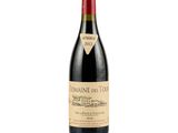 a bottle of red wine sitting on top of a white table