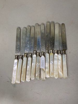 six couteaux sont alignés sur une table