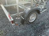 a trailer with a trailer attached to it in a gravel lot