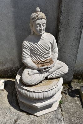a statue of a buddha sitting on top of a pedestal